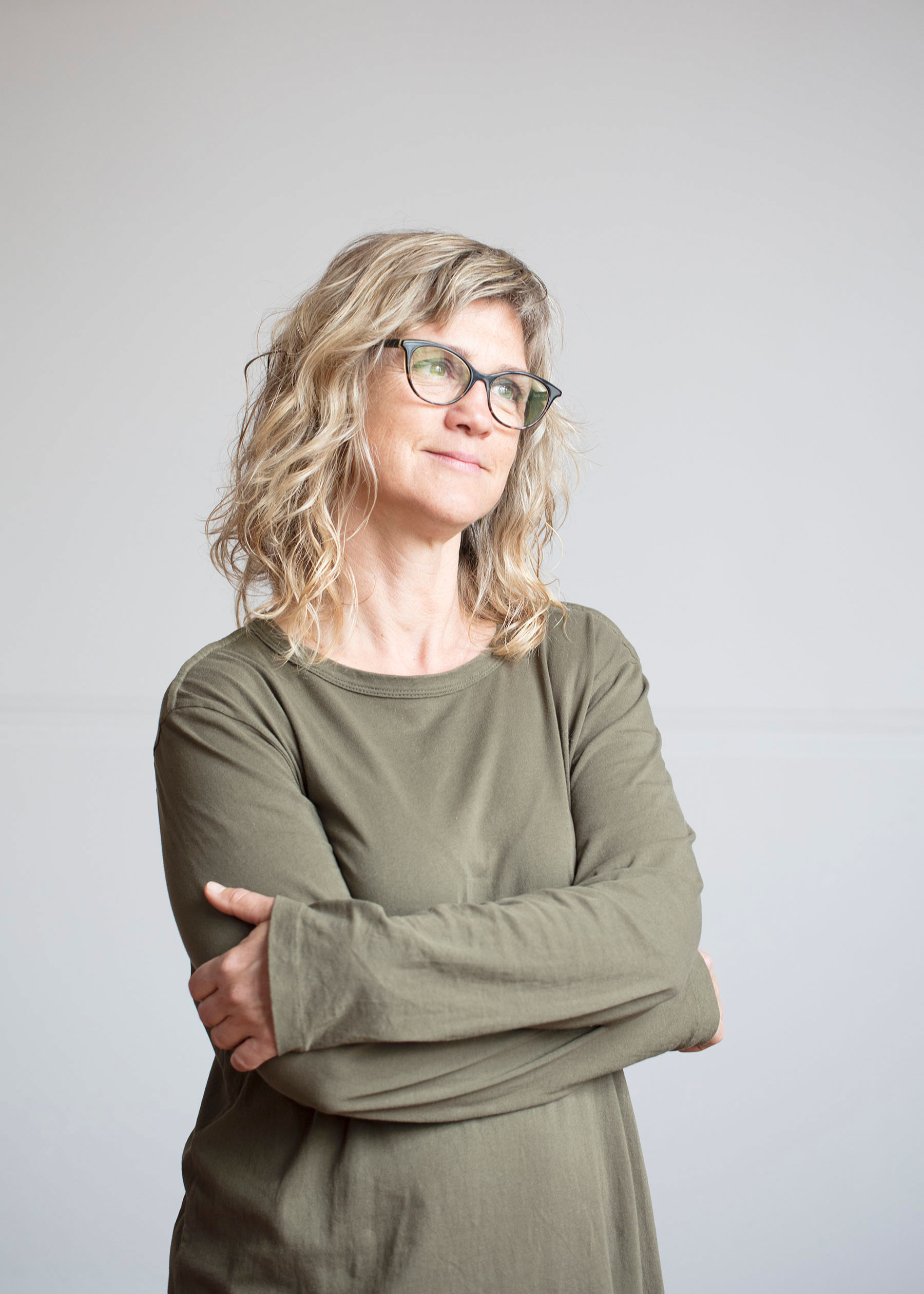 woman in khaki dress and glasses smiling
